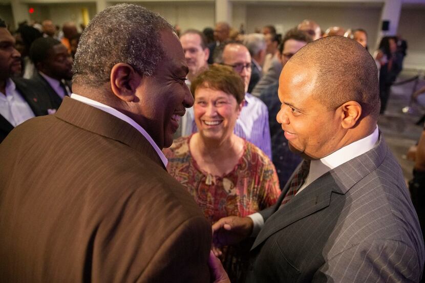 State Sen. Royce West, left, chats with Mayor-elect Eric Johnson after giving remarks during...