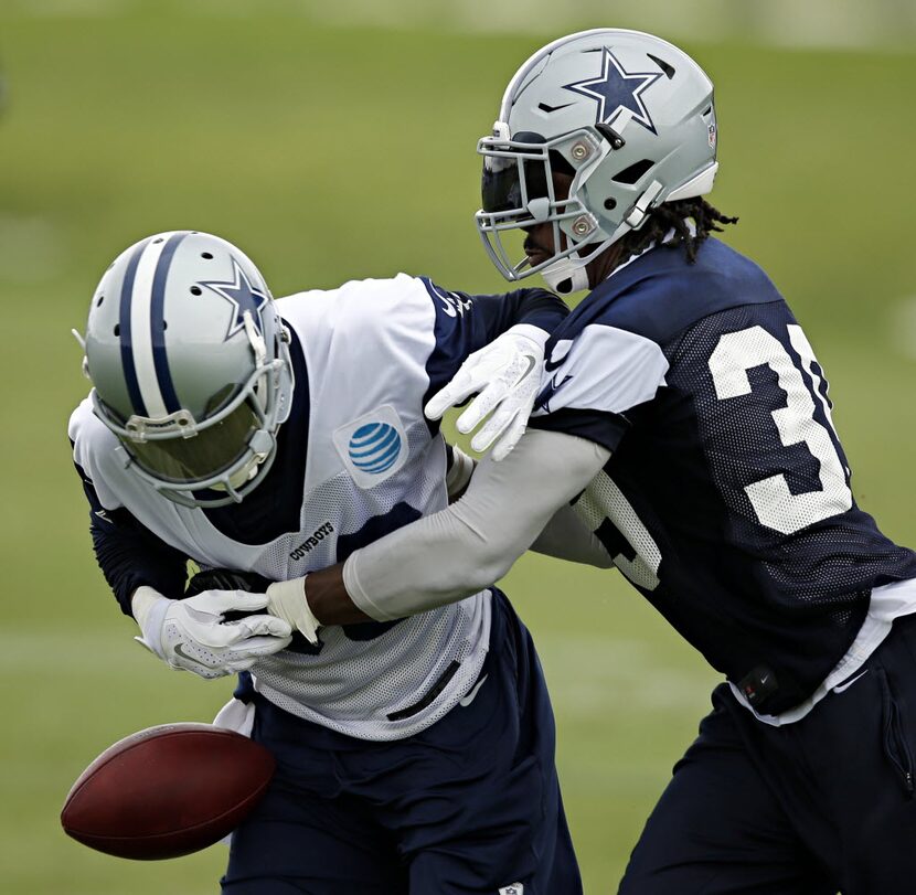 Dallas Cowboys cornerback Brandon Carr (right) strips the ball from wide receiver Terrance...