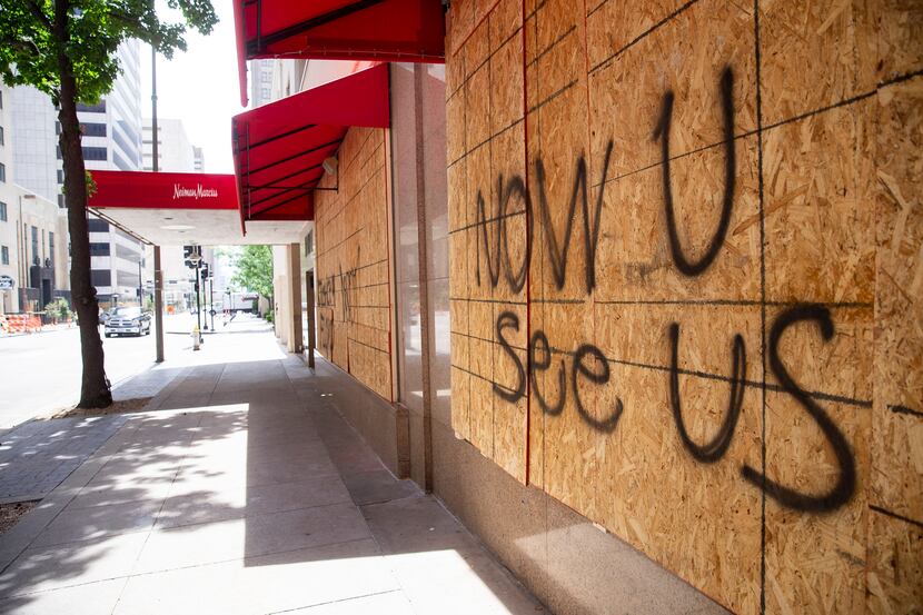 Messages were spray-painted on the boarded-up windows of downtown Dallas' Neiman Marcus on...