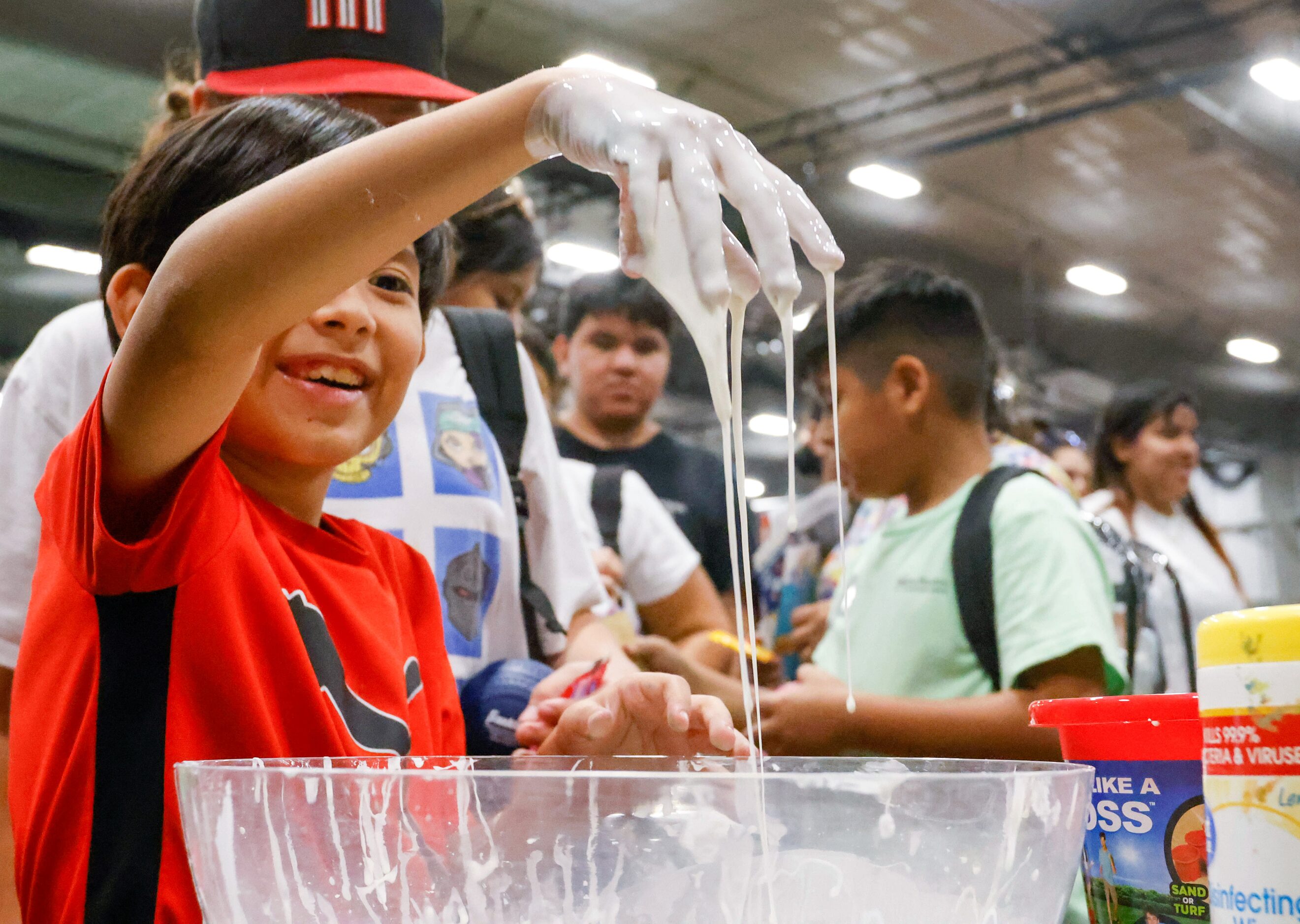 Adam Muniz (front), 9, pulls his hand out of a bowl of slime brought by Buckner to the...