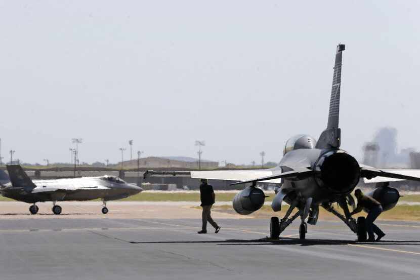 Crew members prepare a F-16 to escort an Air Force version of the F-35 for a test flight at...