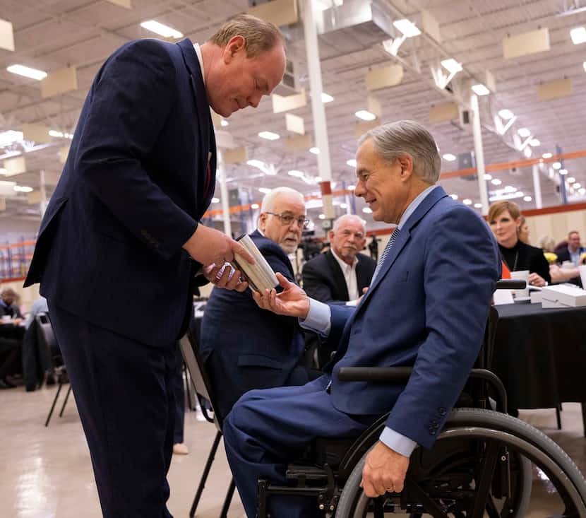 Denton County Judge Andy Eads gives Texas Gov. Greg Abbott a gift during the Denton County...
