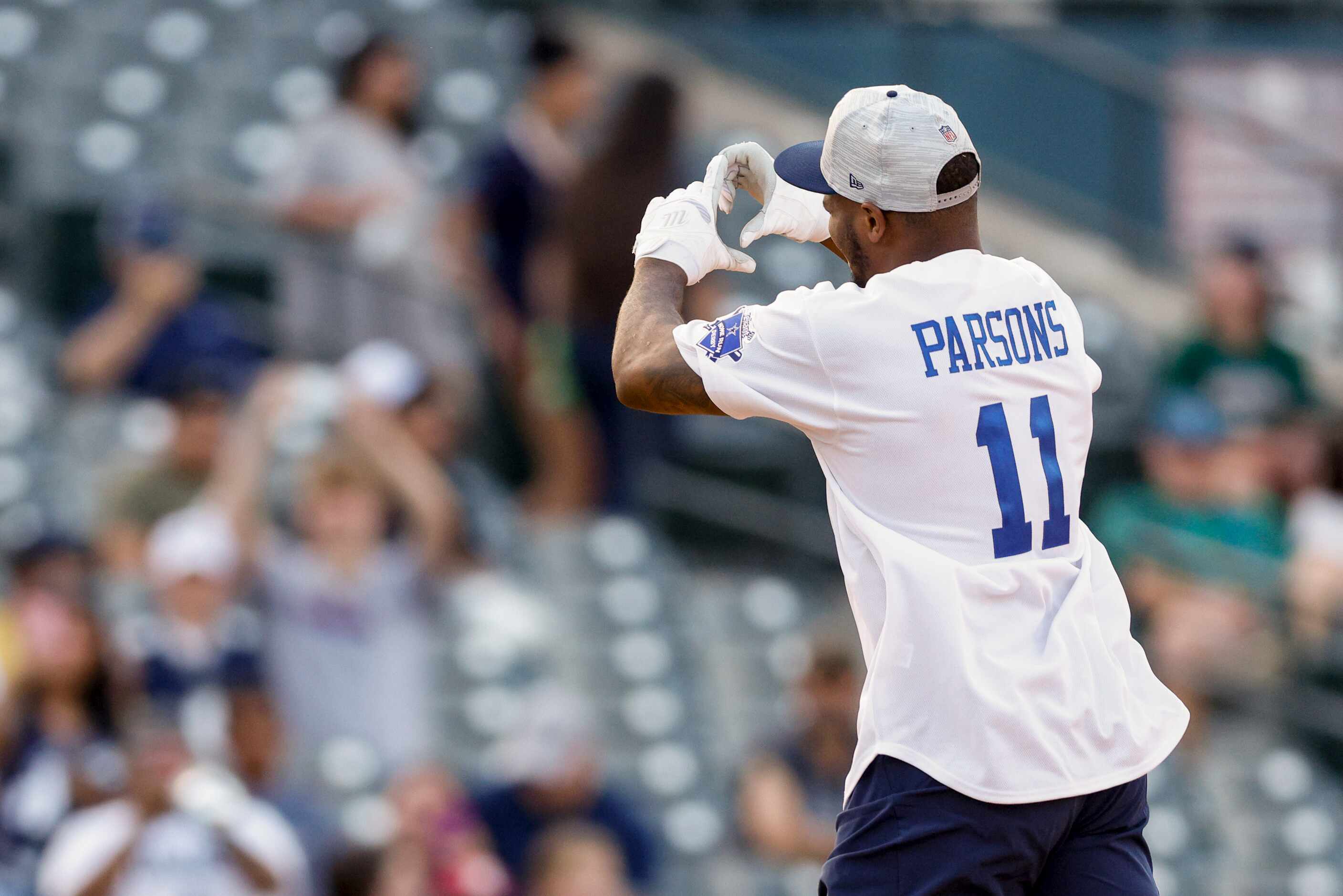 Dallas Cowboys linebacker Micah Parsons shows a heart to fans as he rounds the bases after...