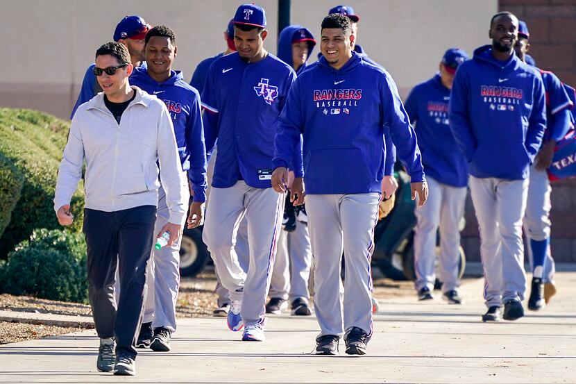 Texas Rangers general manager Jon Daniels (left) walks with players to a team meeting before...