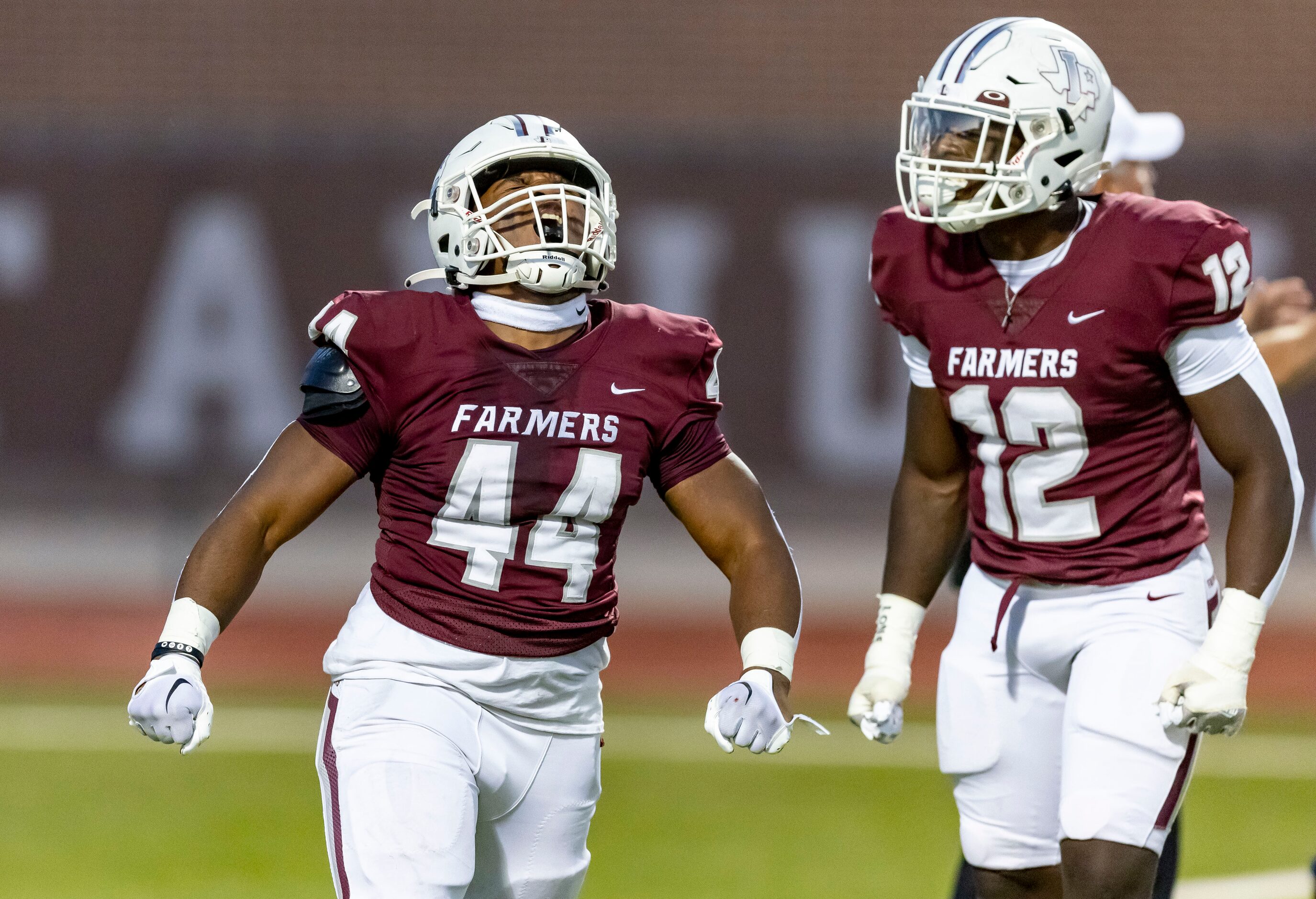 Lewisville junior linebacker Mark Cooper (12) looks on as senior defensive lineman Mason...