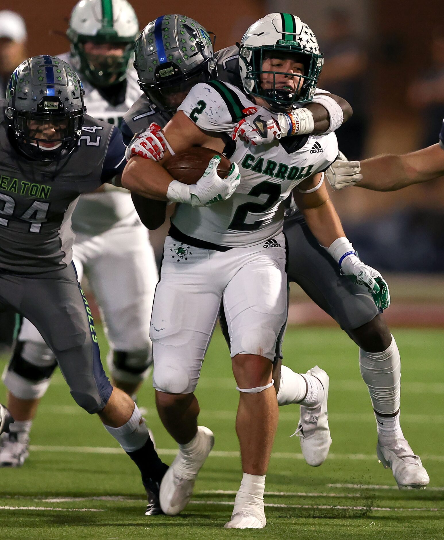 Southlake Carroll running back Owen Allen (2) gets hauled down by Eaton defensive end Israel...