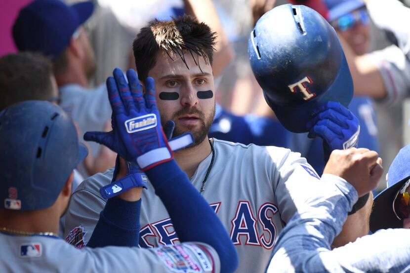 Texas Rangers' Joey Gallo, center, is greeted in the dugout after hitting a two-run home run...