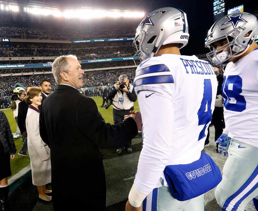 Former President George W. Bush shakes hands with Dallas Cowboys quarterback Dak Prescott...