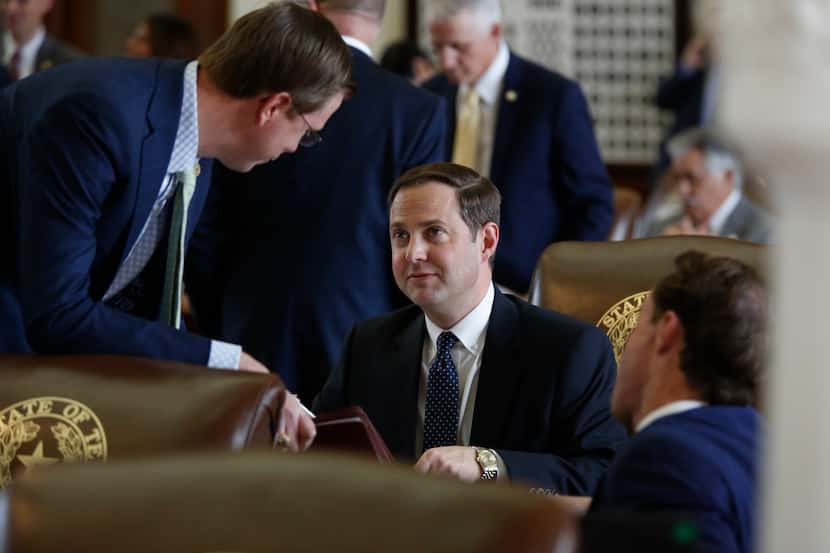 Rep. Dustin Burrows, R-Lubbock, (right) talks with Rep. Will Metcalf (left), R-Conroe, in...