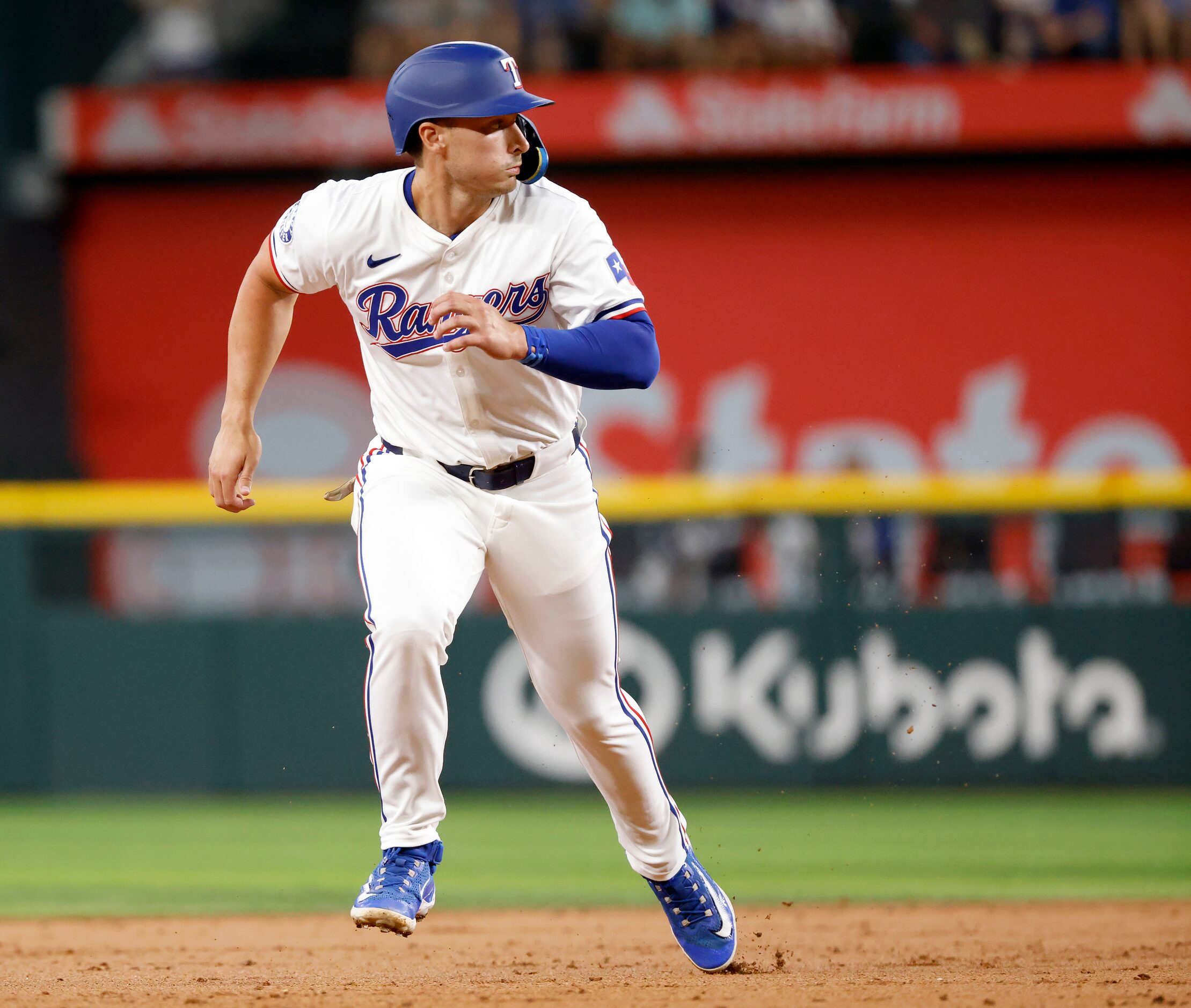 Texas Rangers designated hitter Justin Foscue breaks for third before scoring on a Andrew...