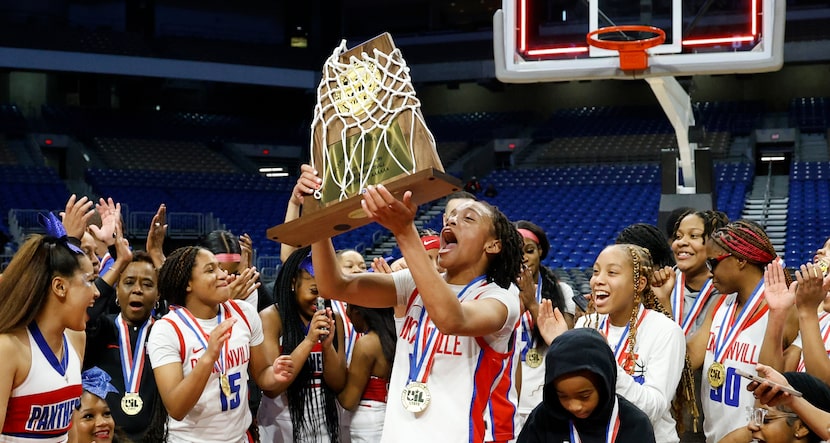 Duncanville's Chloe Mann (0) lifts the trophy after the UIL Class 6A girls basketball state...