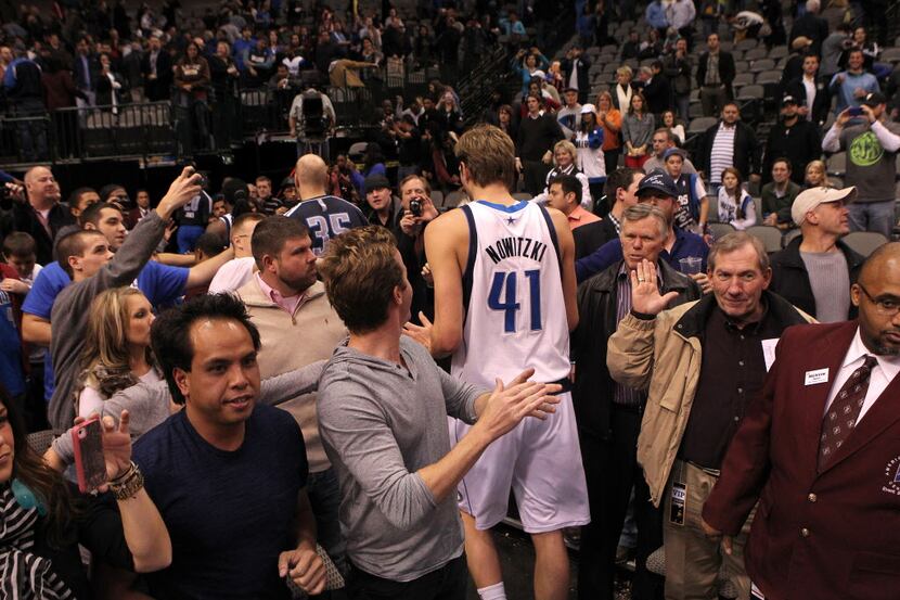 Dallas Mavericks power forward Dirk Nowitzki (41) is greeted by fans as he leaves the court...