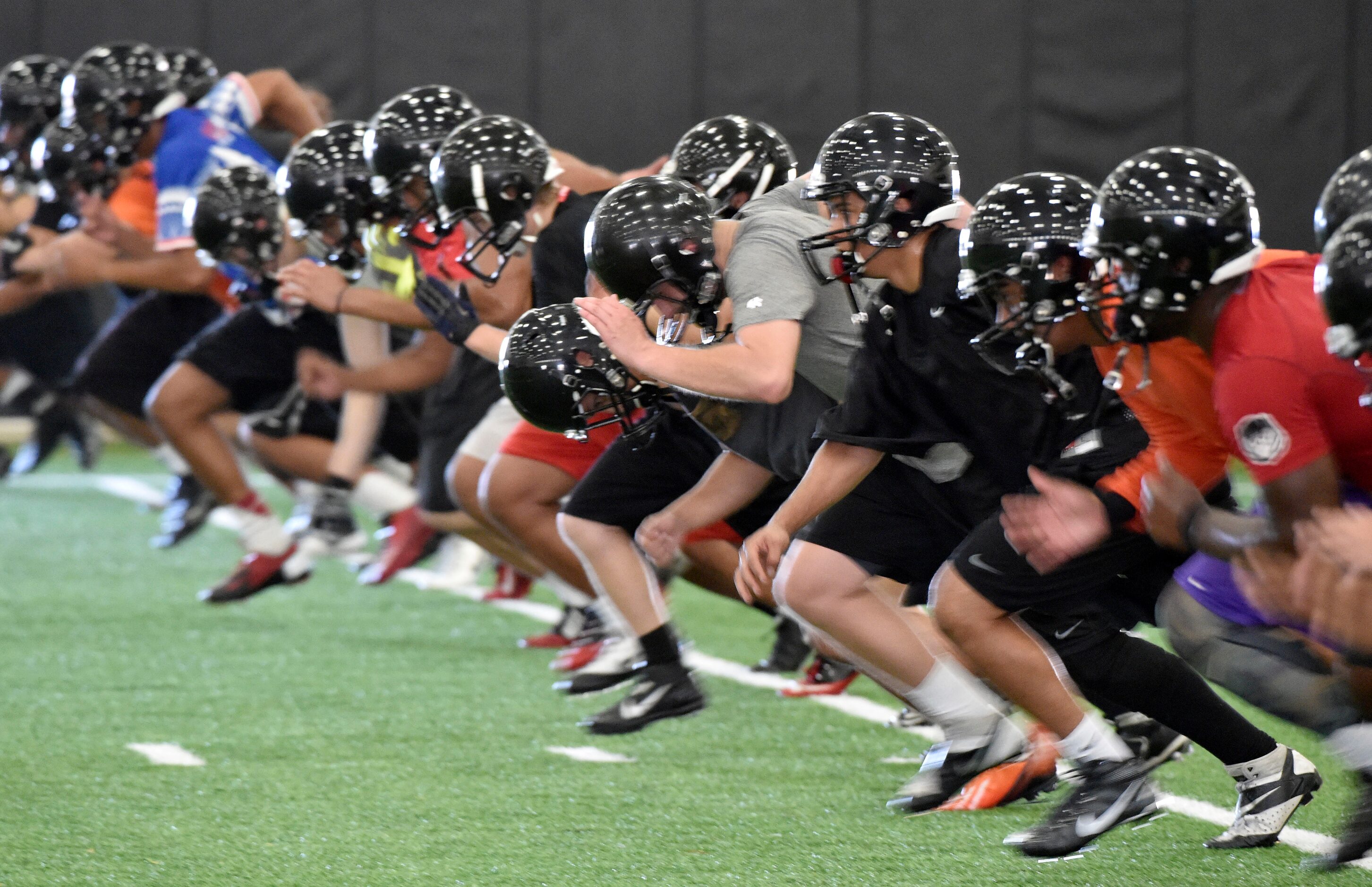 Players start some spirits during Euless Trinity's first day of football practice at the...