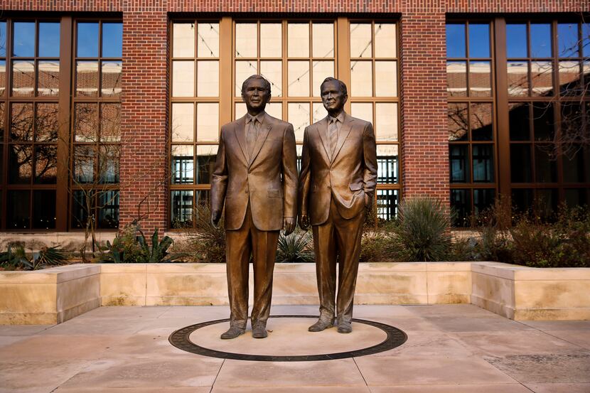 Bronze statues of former Presidents George W. Bush and George H.W. Bush are seen in the...