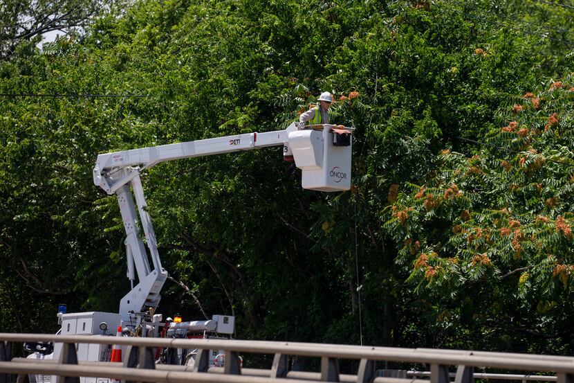 Oncor workers attempt to fix power lines on Samuell Boulevard in Dallas on June 10, 2019....