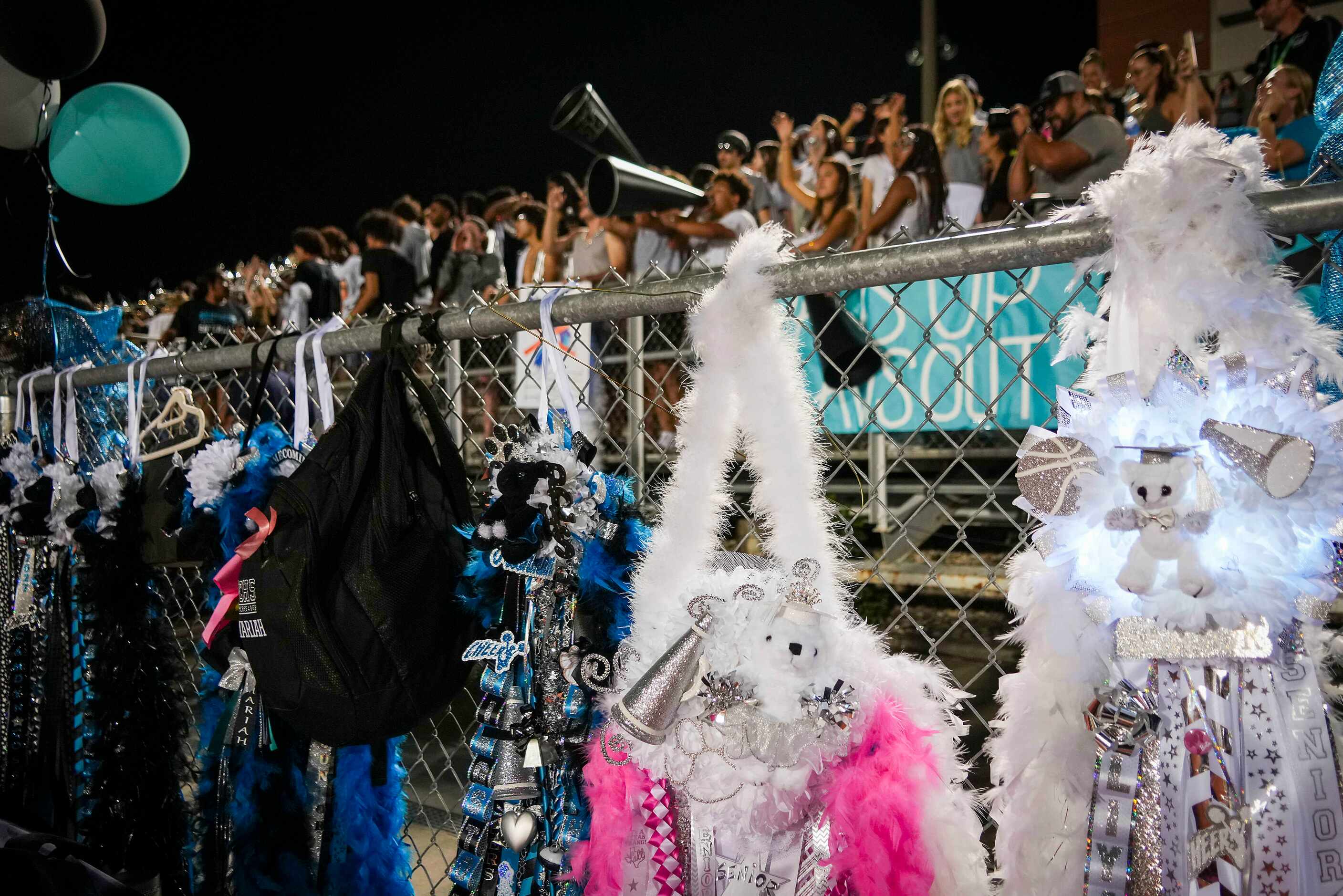 Homecoming mums line the fence on the Panther Creek sideline during the second half of a...