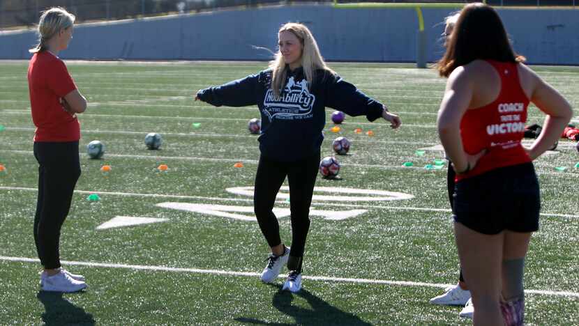 Coach Delaney Kerby (center) explains an exercise with other cheer coaches. The NubAbility...