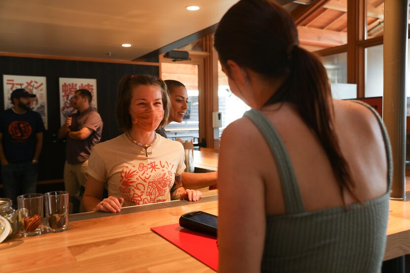 Loro bartender Demitria Lowe presents drinks from an order to guest Michelle Peterson from...