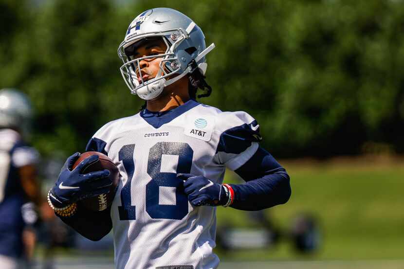 El receptor de los Dallas Cowboys, Jalen Tolbert, captura un pase en el campo de práctica...