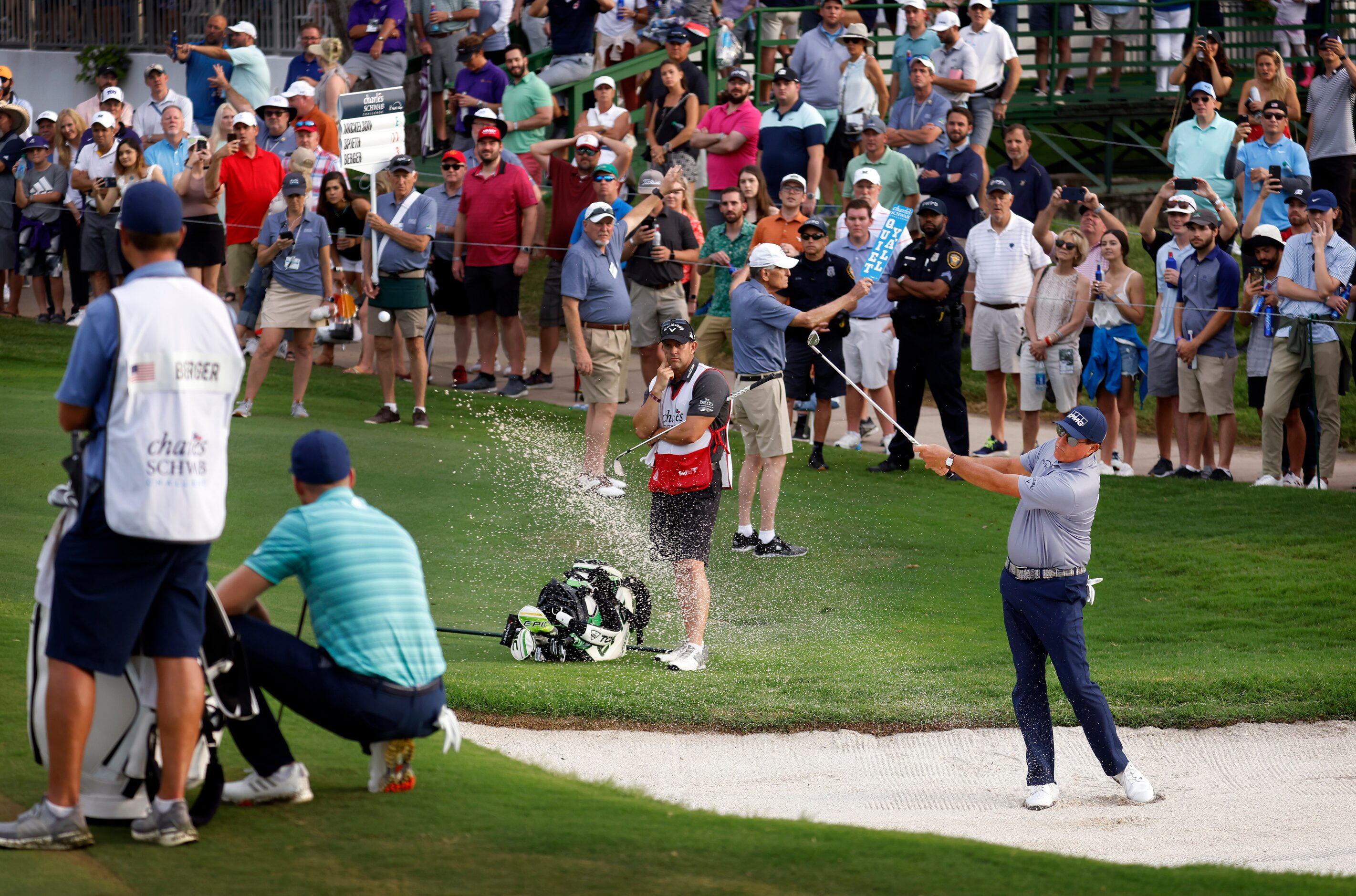 Professional golfer Phil Mickelson hits out of the  par-3, No. 16 green side bunker during...