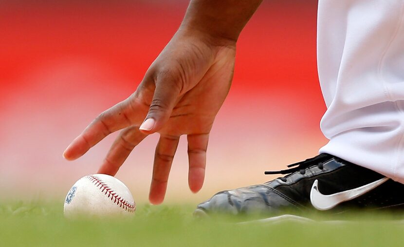 The bat boy fields a foul ball that came to rest along the third base line during an...