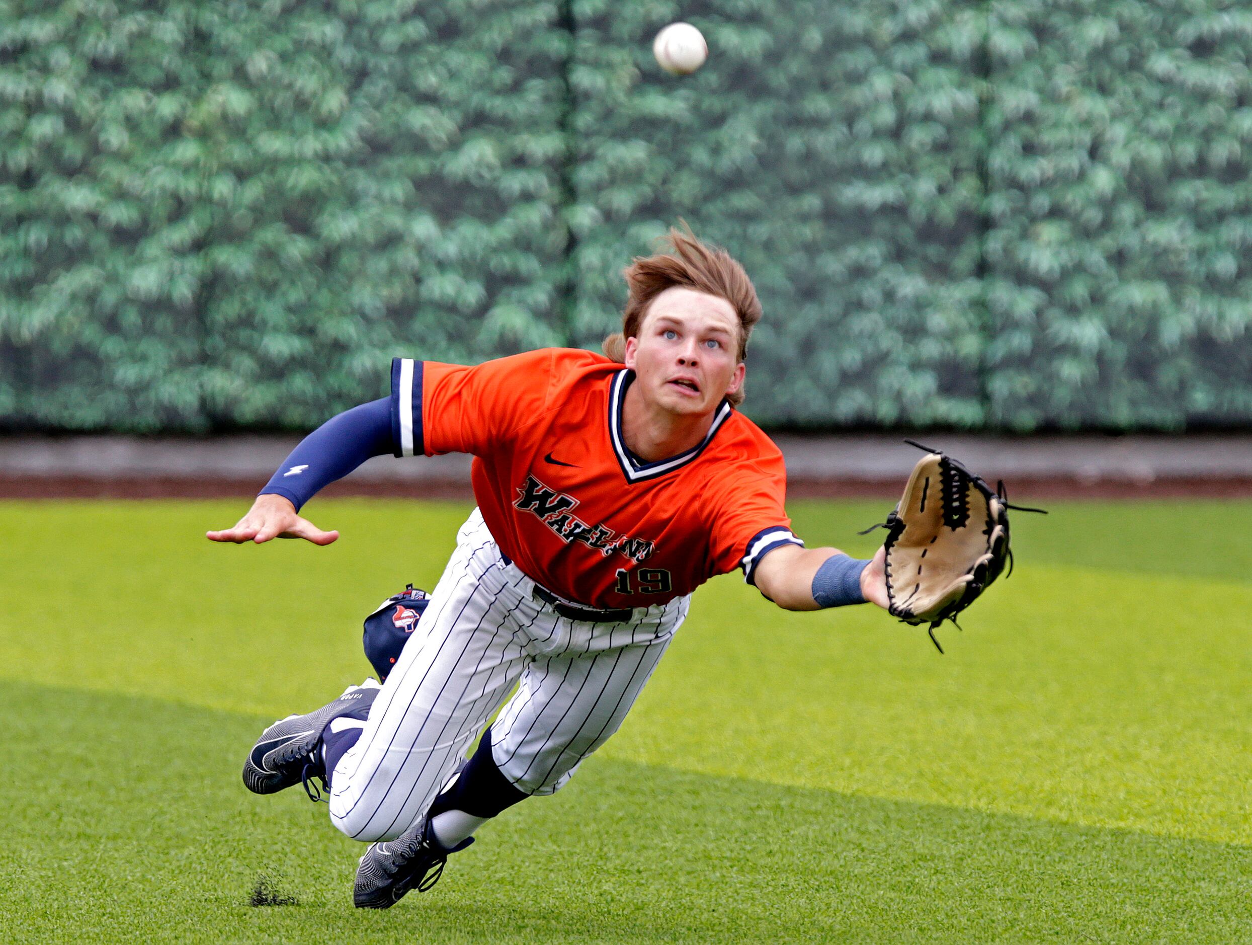Wakelnad High School right fielder Brennan Myer (19) makes a diving catch to end the fifth...