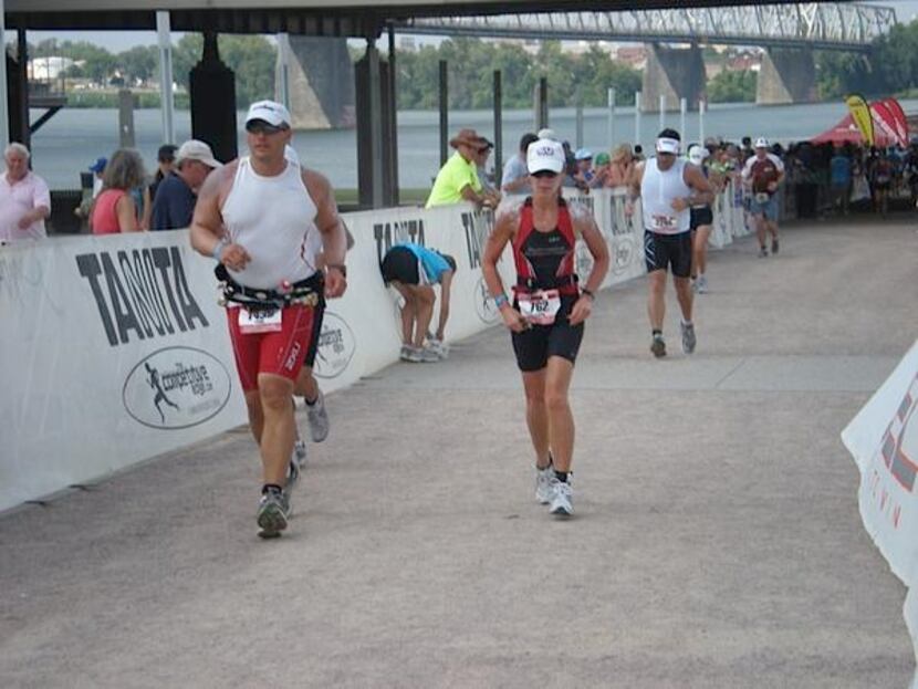 
Hoffman (right) runs the last leg of the 2010 Louisville Ironman triathlon after swimming...