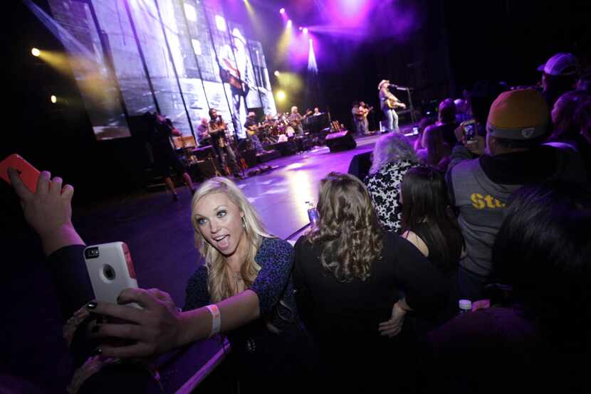 Fans cheer and take photographs as Alan Jackson performs at Verizon Theatre in Grand...