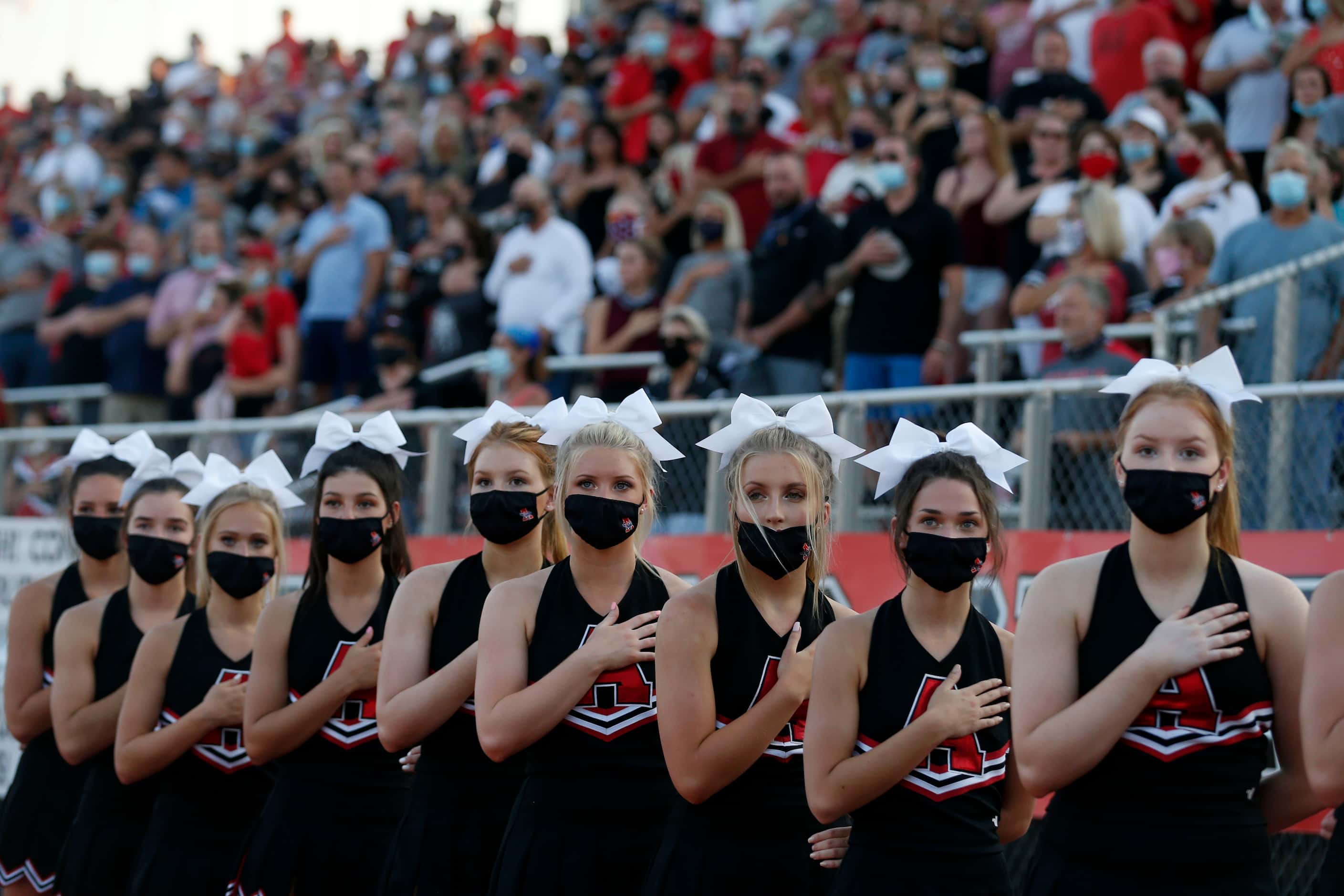 The Argyle cheerleaders and fans stand for the National Anthem during a high school football...