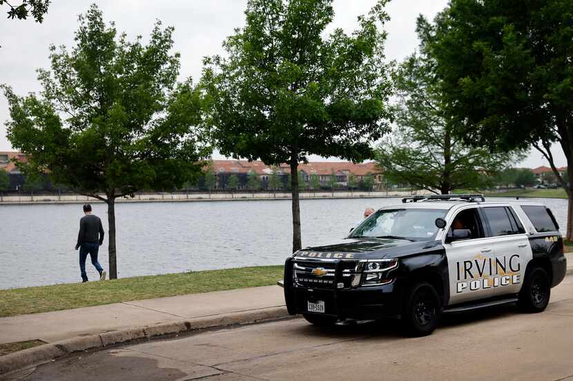 An Irving police officer is pictured along Lago de Claire where Lashun Massey went missing...
