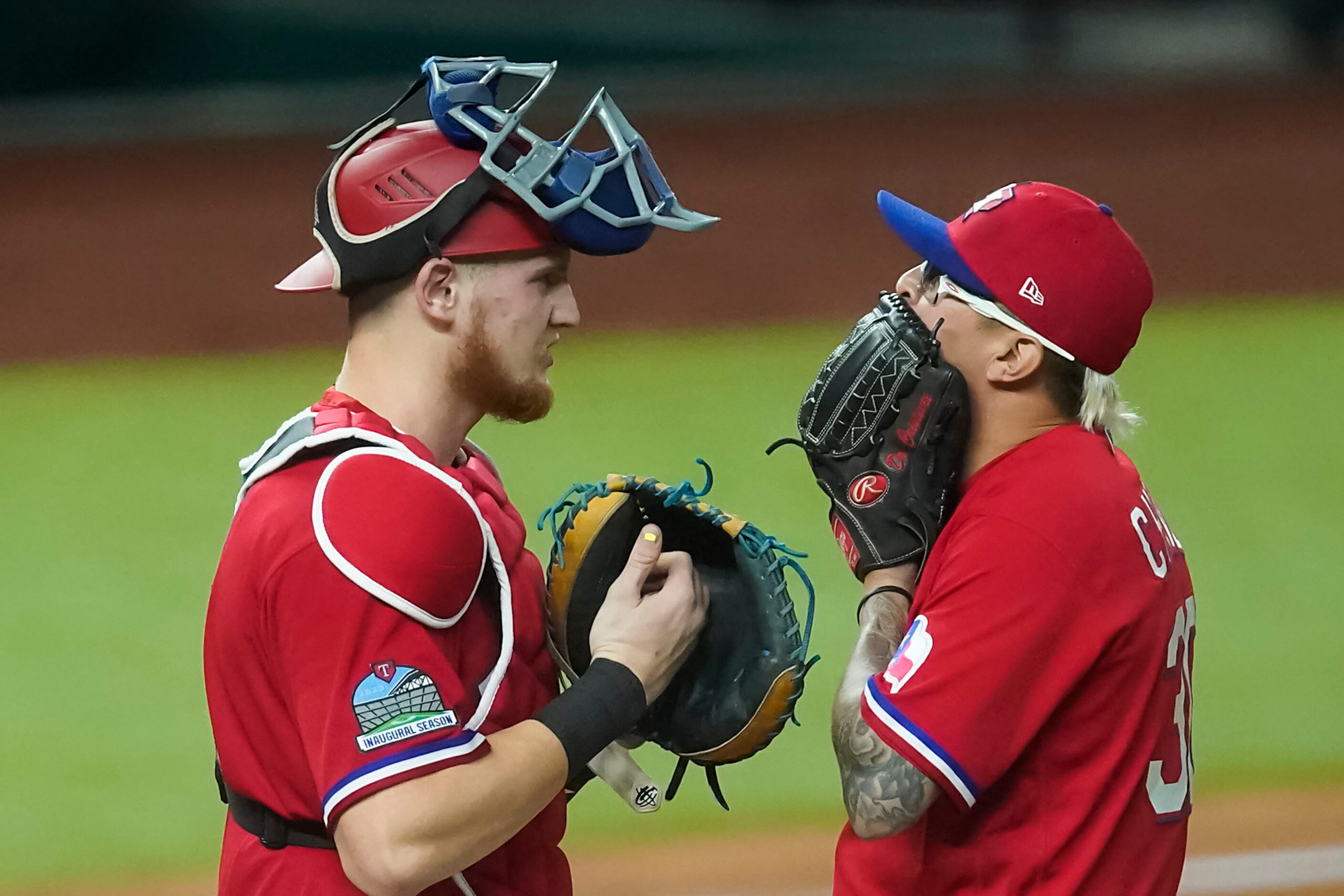 Texas Rangers relief pitcher Jesse Chavez gets a visit from catcher Sam Huff as he comes...