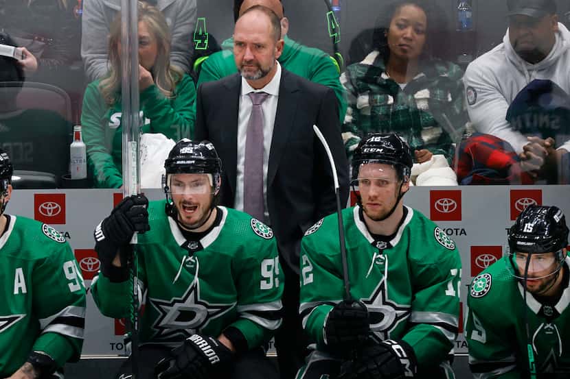 Dallas Stars head coach Peter DeBoer, center, watches his players during the third period of...