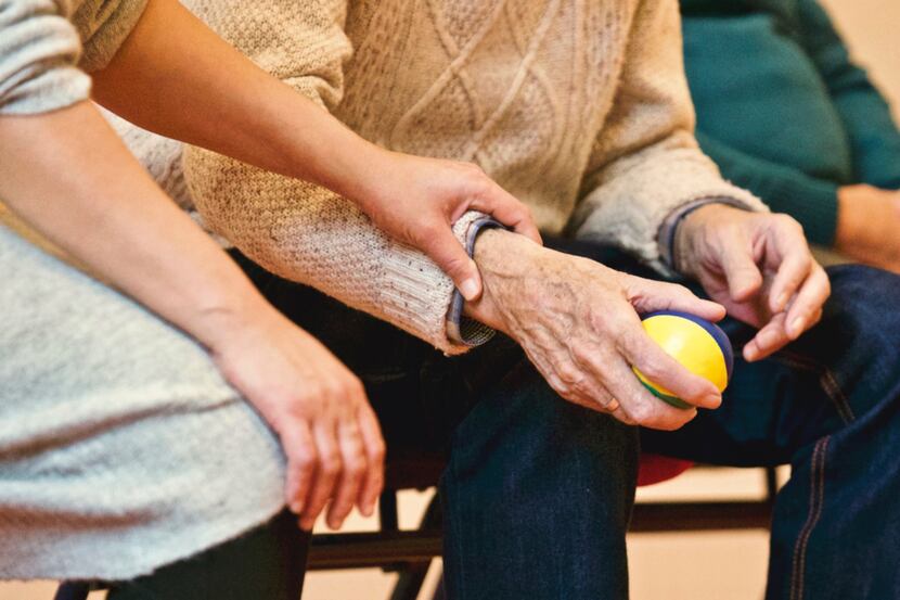 Young women touching the wrist of an elderly man