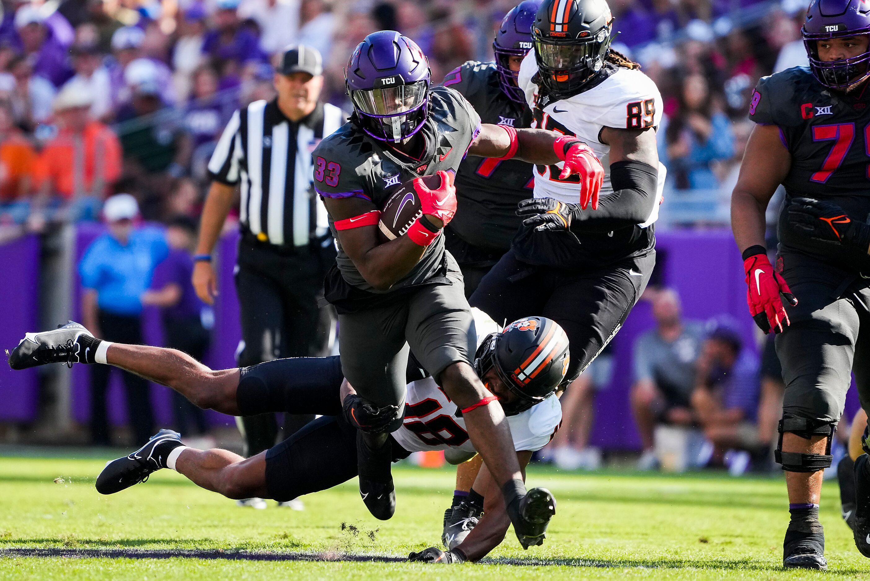 TCU running back Kendre Miller (33) gets past Oklahoma State safety Sean Michael Flanagan...