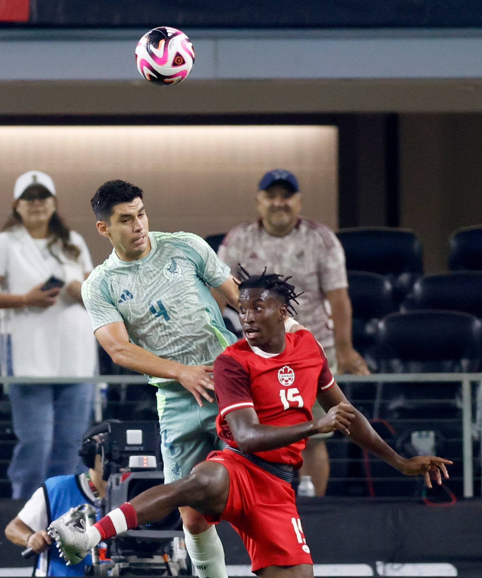 Mexico defenseman Jesus Angulo (4) heads the ball away from Canada defenseman Moise Bombito...