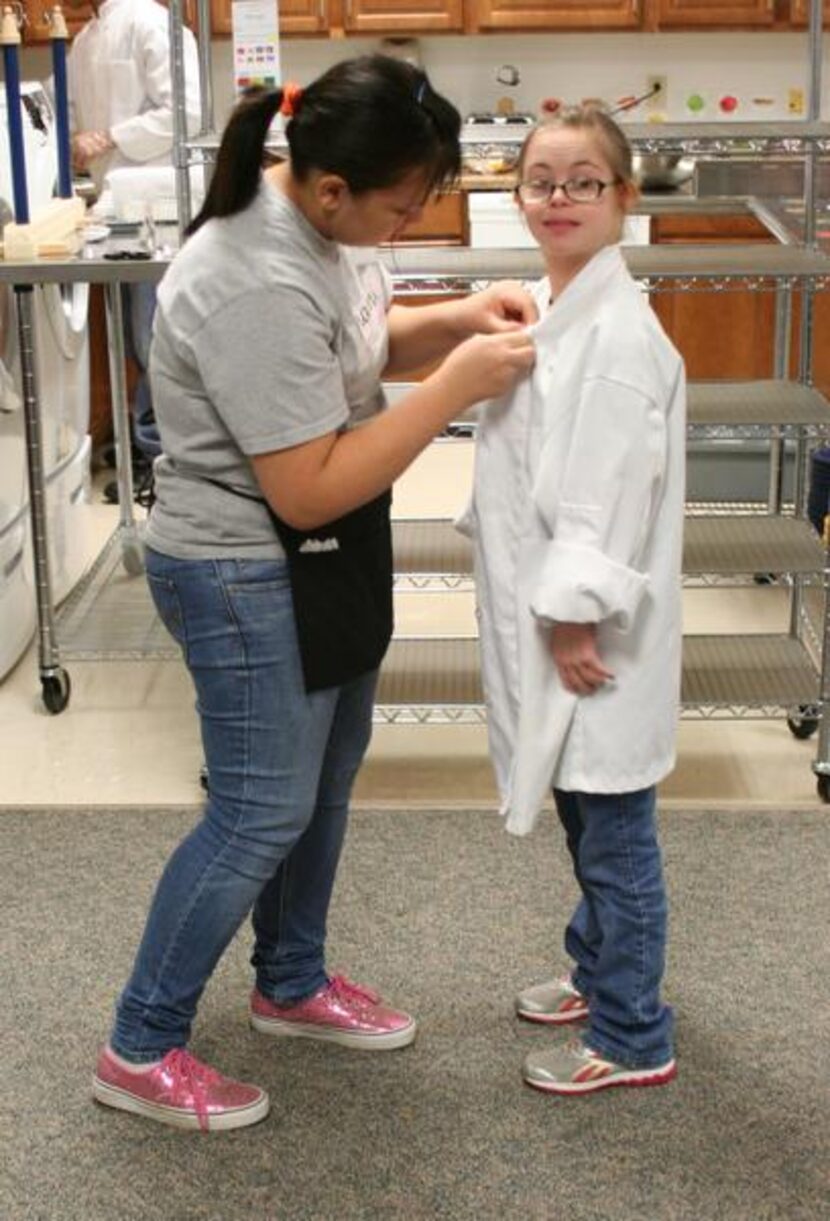 
Vynami waitress Maria Arboleda helps fellow Vynami worker Catherine Bruscino, 17, get into...