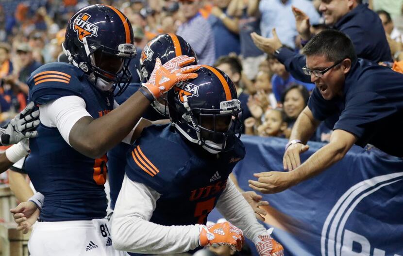 UTSA wide receiver Kerry Thomas Jr. , center, celebrates with fans and teammates after...