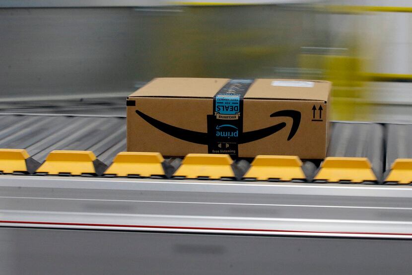FILE- In this Feb. 9, 2018, file photo, a box for an Amazon prime customer moves through the...