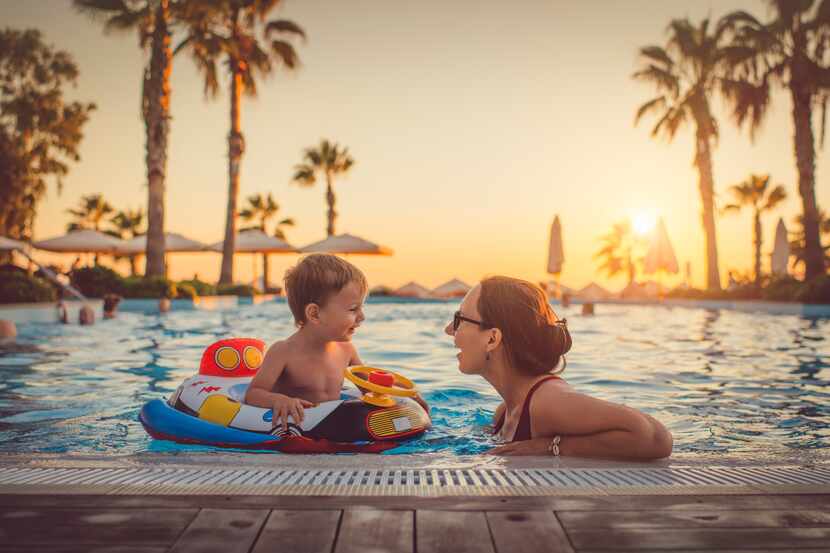 Mom swimming with young child in pool floatie