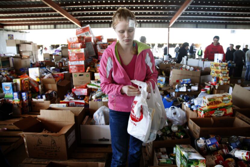Veronica McAllister, a West resident who was injured in the explosion, gathers food items...