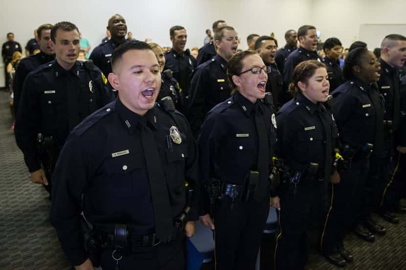 New Dallas police officers recite their class motto after receiving their badges on...