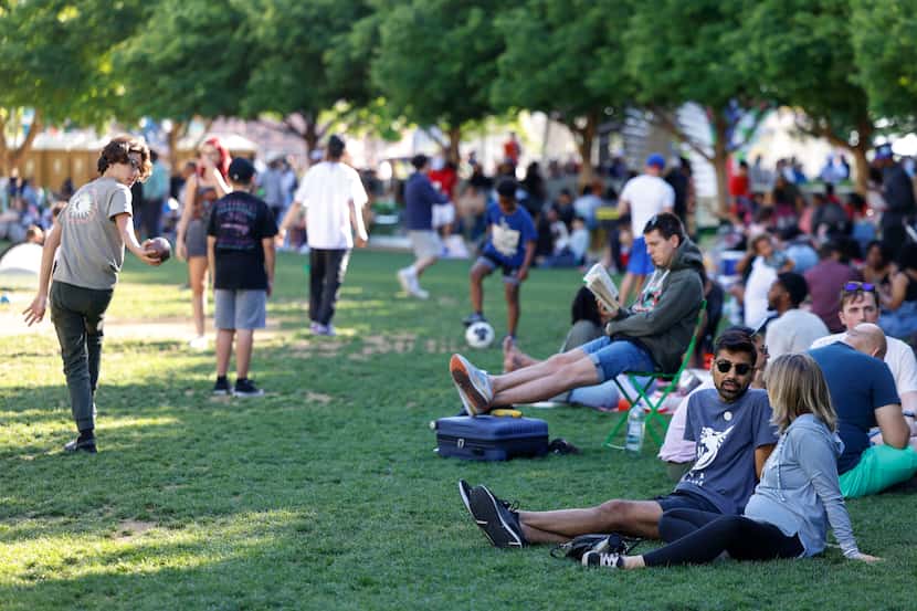 People walk around enjoy their time at the lawn of Klyde Warren Park, a day before total...