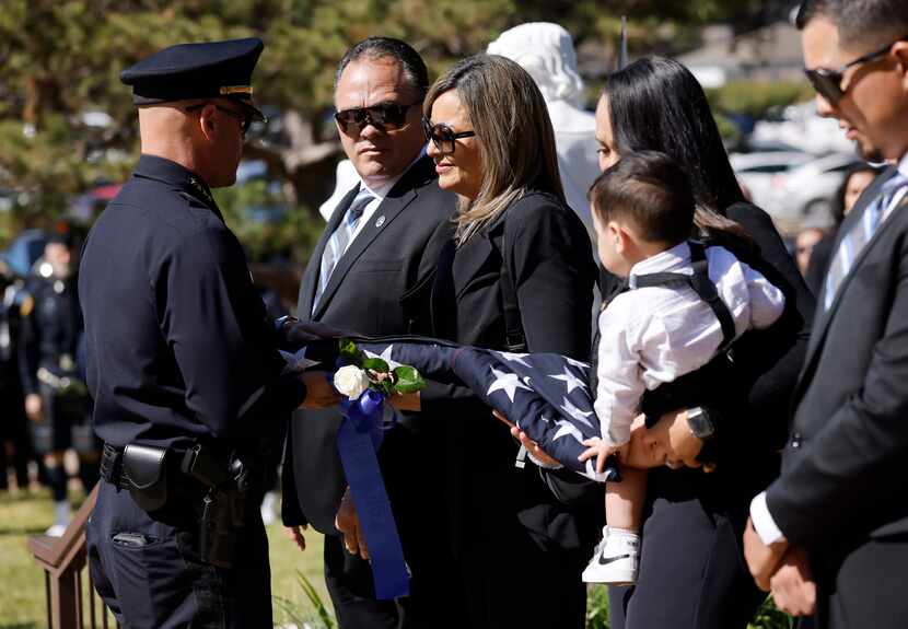 Dallas Police Officer Jacob Arellano’s parents Frank and Rebecca Arellano (center) receive a...