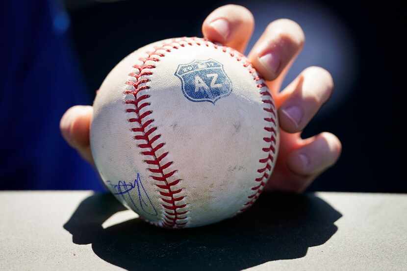 A Texas Rangers fan holds a ball hoping for autographs before a spring training game against...