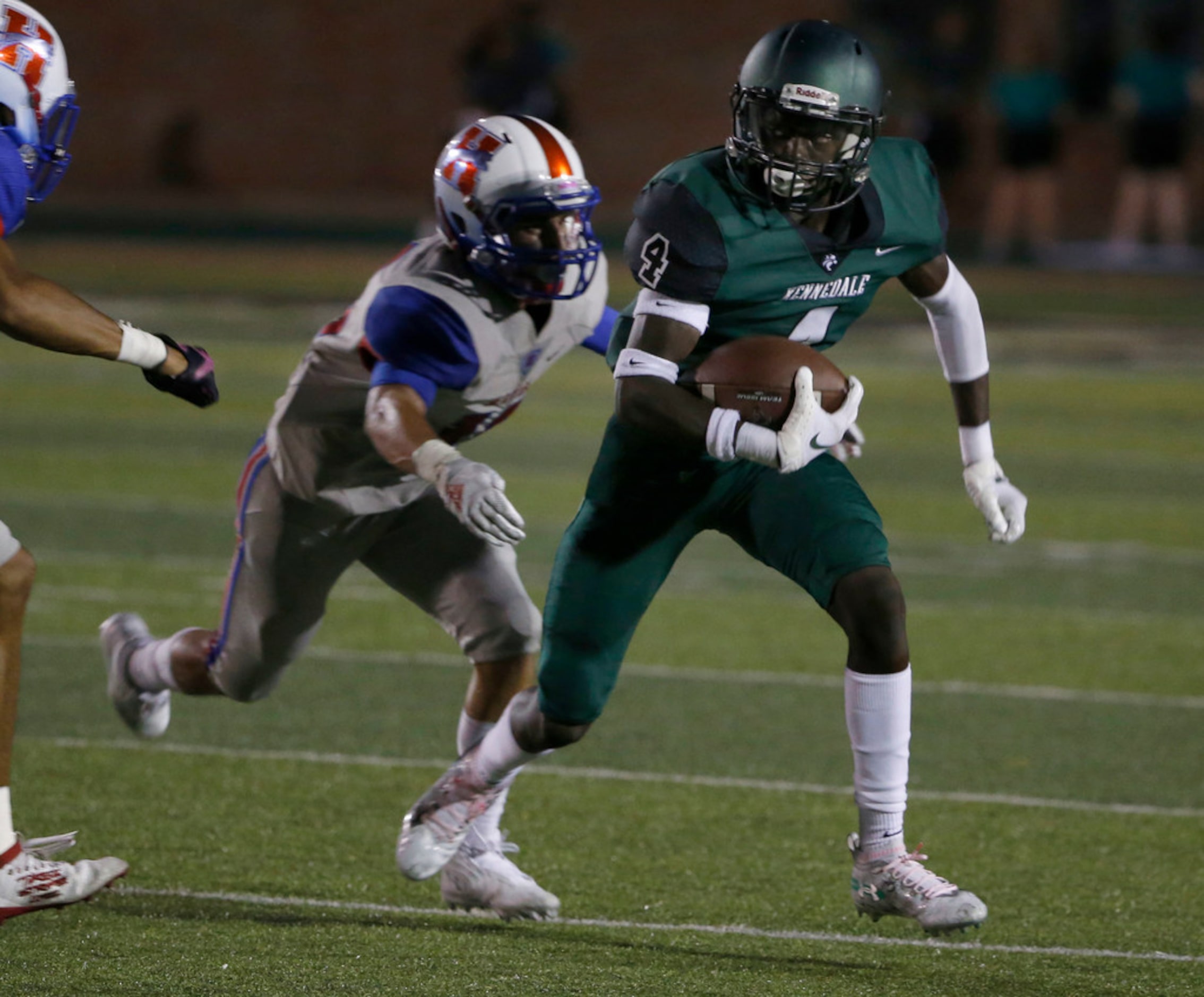 Kennedale quarterback Ife Adeyemi (4) tries to get past Midlothian Heritage defender Wyatt...