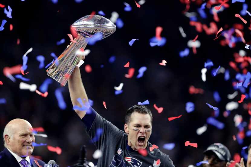 Tom Brady reacts with the Vince Lombardi Trophy after winning the NFL Super Bowl 51 football...
