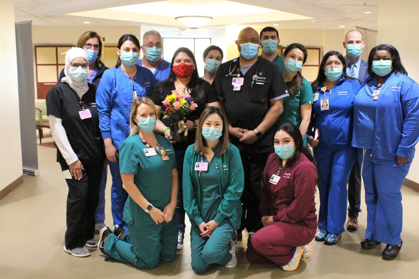 Luisa Garcia, holding flowers, is surrounded by the medical team that treated her at Medical...
