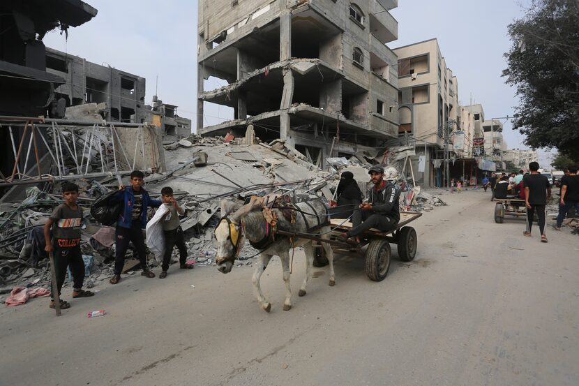 Palestinians pass by the destruction after the Israeli bombardment of the Gaza Strip in...