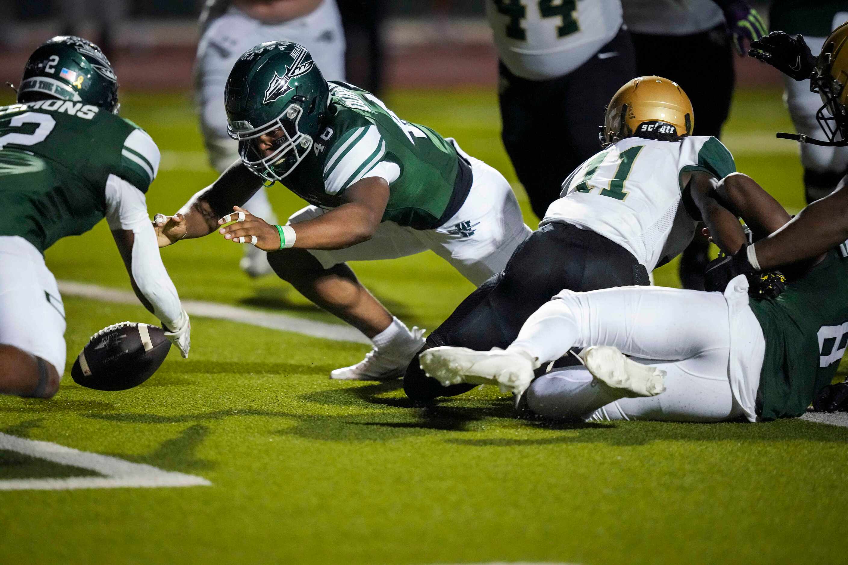 Waxahachie running backs Wade Lemons (2) and Joshua Durham (48) dive for a fumble in the end...