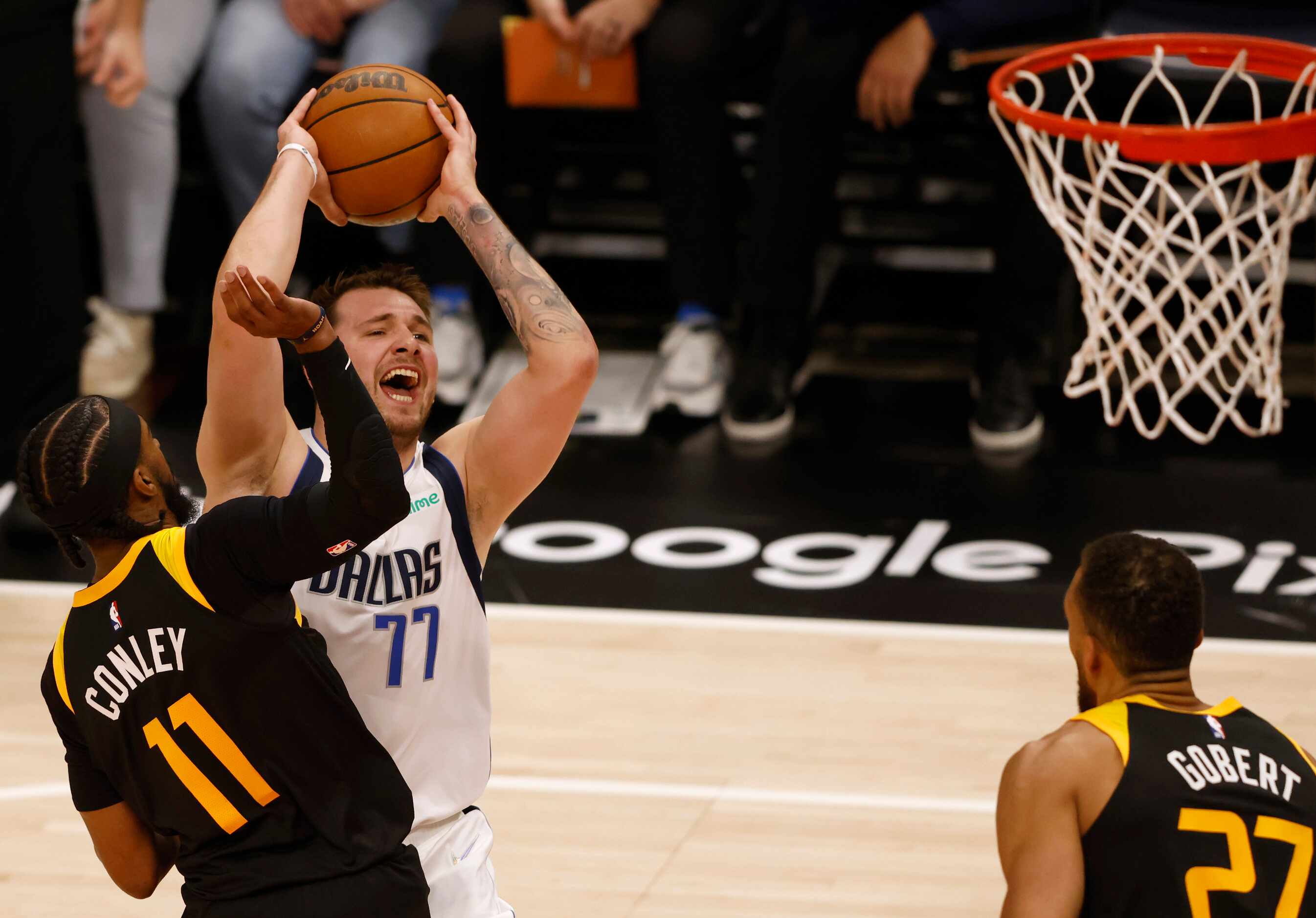 Dallas Mavericks guard Luka Doncic (77) yells as he attempts a shot in front of Utah Jazz...